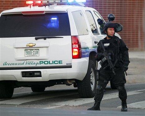 A SWAT team officer stands watch near an apartment house where the suspect in a shooting at a movie theatre lived in Aurora, Colo., Friday, July 20, 2012.