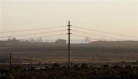 Electricity lines are seen with the backdrop of the industrial port of Saldanha bay, South Africa, Saturday, March 8, 2008. As world economy have been under sever pressure with falling American house and stock prices, South Africa is facing an added energy crisis. (AP Photo/Schalk van Zuydam)hg3