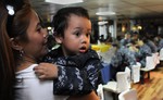 A child looks at his father, Culinary Specialist 2nd Class Rowin Lameque, during a Father's Day celebration lunch aboard the U.S. 7th Fleet command ship USS Blue Ridge (LCC 19).