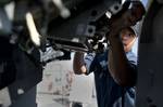 Gunners Mate 1st Class Johnny Salinas performs maintenance on a Mk 38 MOD 2 25mm machine gun system aboard the amphibious dock landing ship USS Pearl Harbor (LSD 52).