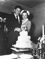 Newlyweds Ronald Reagan and Nancy Reagan cutting their wedding cake, 03/04/1952