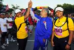 Xanana Gusmao, the Prime Minister of Timor-Leste, high fives Cmdr. Veronica Armstrong during the Marathon for Peace race in Dili. Fifty personnel participating in Pacific Partnership 2011