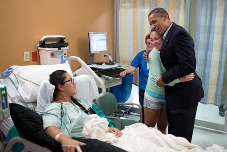 President Barack Obama hugs Stephanie Davies, who helped keep her friend, Allie Young, left, alive after she was shot during the movie theater shootings in Aurora, Colorado. The President visited patients and family members affected by the shootings at the University of Colorado Hospital, July 22, 2012.