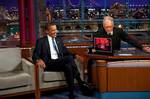 United States President Barack Obama laughs at a photograph of himself watching the 2009 Superbowl using 3D glasses shown by Late Show host David Letterman during their interview at CBS Studios in New York City on 21 September 2009.