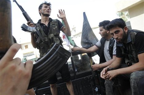 Syrian rebels sit in a pick up truck in Aleppo, Syria, Saturday, July 28, 2012.