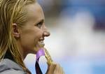 United States' Dana Vollmer poses with her gold medal for the women's 100-meter butterfly swimming final at the Aquatics Centre in the Olympic Park during the 2012 Summer Olympics in London