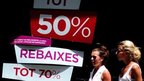 Women walk past shop in Barcelona