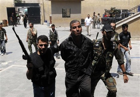 In this photograph made on Friday, July 27, 2012, Syrian rebels arrest a man who they said was a government informant in Aleppo, Syria.