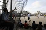 Palestinian youths playing football during a local match a little before sunset in Rafah refugee camp in the southern Gaza Strip on July 28, 2012. Palestinians organize Ramadan Olympics in conjunction with the ongoing Olympic Games in London, while Muslims around the world abstain from food, drink and sex from sunrise to sunset during Ramadan the holiest month in the Islamic calendar.Photo by Ahmed Deeb / WN