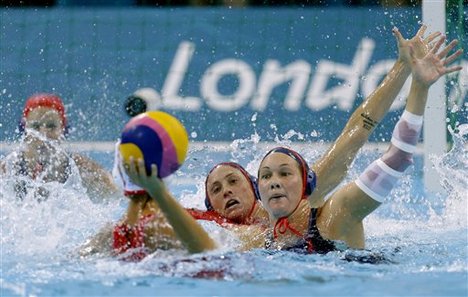 Heather Petri of the United States, right attempts to block a shot on goal by Lorena Miranda Dorado of Spain during their women's water polo preliminary round match at the 2012 Summer Olympics, Wednesday, Aug. 1, 2012, in London.