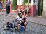 Humble Boy playing the accordion in the street and asking money. Buenos Aires, Argentina.