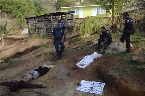 Police wait for forensic workers after two people were slain inside a primary school, prior to the arrival of students, in the Pacific resort city of Acapulco, Mexico, Mayo 30, 2012. Several messages from a drug gang were left next to the bodies.