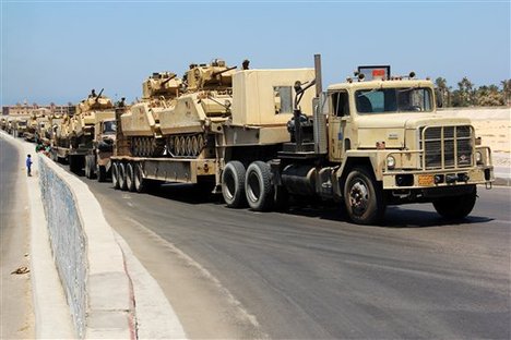 Army trucks carry Egyptian military tanks in El Arish, Egypt's northern Sinai Peninsula, Thursday, Aug. 9, 2012. Gunmen sprayed a police station in Egypt’s Sinai with bullets Thursday, setting off a brief firefight with policemen before speeding away in their truck, the latest in a series of attacks against security forces in the increasingly volatile peninsula, security officials said.