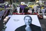 Fresh apples, flowers and a large poster of Steve Jobs are placed outside an Apple retail store in Beijing, China, Thursday, Oct. 6, 2011.