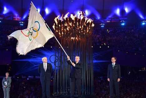 The Olympics flag is handed from London Mayor, Boris Johnson, second from left, to the International Olympic Committee President Jacques Rogge, center, next to the Mayor of Rio de Janeiro, Eduardo Paes, right, during the Closing Ceremony of the 2012 Summer Olympics on Sunday, Aug. 12, 2012, in London.