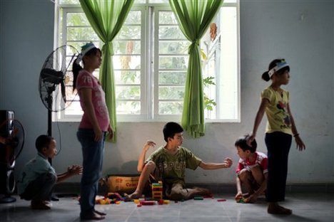 In this photo taken on Wednesday, Aug. 8, 2012, Dang Cong Chinh, center, plays with other children at a rehabilitation center in Danang, Vietnam. The children were born with physical and mental disabilities that the center's director says were caused by their parents' exposure to the chemical dioxin in the defoliant Agent Orange.