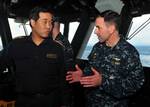 Capt. David Fluker, commanding officer of the forward-deployed amphibious assault ship USS Essex (LHD 2), discusses ship capabilities with Japan Maritime Self-Defense Force Rear Adm. Hiroyuki Kasui.