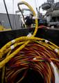 Navy Diver 2nd Class Jason Hatch, assigned to Mobile Diving and Salvage Unit (MDSU) 2, removes an umbilical cord during a dive station set-up aboard the Military Sealift Command rescue and salvage ship USNS Grasp (T-ARS 51).