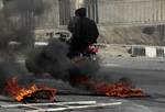 Anti-Syrian government protesters, ride their motorcycle as they pass next to burning tires, in the southern city of Daraa, Syria, Wednesday March 23, 2011. Syrian security forces shot live ammunition and tear gas early Wednesday near a mosque where protesters have been camped out in southern Syria, killing six people including a paramedic, activists said. The early morning attack near the al-Omari mosque in the southern city of Daraa marks the deadliest single day since anti-government protests