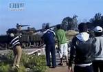 This video image taken from amateur video released by Sham News Network, a Syrian Freedom group, shows a man, left, preparing to throw an object at a tank as others look on, in Daraa, Syria Sunday April 24, 2011. An eyewitness says at least five people have been killed in the southern Syrian city of Daraa during a security crackdown. Syrian troops in armored vehicles and tanks stormed the southern town of Daraa early Monday April 25, 2011 and opened fire. It was the latest bloodshed in a five-we