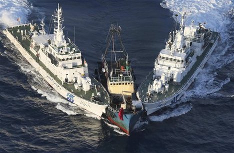 A boat, center, is surrounded by Japan Cost Guard's patrol boats after some activists descended from the boat on Uotsuri Island, one of the islands of Senkaku in Japanese and Diaoyu in Chinese, in East China Sea Wednesday, Aug. 15, 2012.