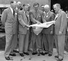 Walt Disney shows Disneyland plans to Orange County officials in December 1954. The men in the front row (left to right) are Anaheim Mayor Charles Pearson, Orange County Supervisor Willis Warner, Walt Disney, Supervisor Willard Smith, and Orange County Planning Commission Chairman Dr. W. L. Bigham. at Disney Studios in Burbank.