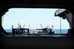 Aviation boatswain's mates prepare to transport two aircraft from elevator 2 into the hangar bay aboard the aircraft carrier USS Ronald Reagan (CVN 76)