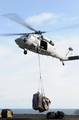 An MH-60S Sea Hawk helicopter prepares to deliver pallets of supplies to USS Ronald Reagan (CVN 76) during a replenishment at sea.