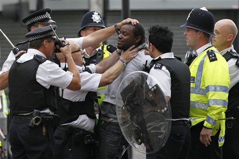 British police officers arrest a man as rioters gathered in Croydon, south London, Monday, Aug. 8, 2011.