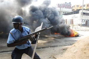 A riot police officer near to a tire on fire, lit by Muslim youths, outside Masjid Musa Mosque, in Majengo, Mombasa, Kenya, Tuesday, Aug. 28, 2012. Police and protesters fought running battles as a violent backlash to the killing of a radical Islamic preacher continued Tuesday in Kenya’s second largest city city of Mombasa, which left several people hospitalized, a police and human rights official said. Police officers teargased rowdy youth on their second day of protests over the killing Monday of Aboud Rogo Mohammed, who was sanctioned by the U.S. government and the U.N. for his alleged connection to an al-Qaida-linked Somali militant group, al-Shabab, regional Police boss Aggrey Adoli said.