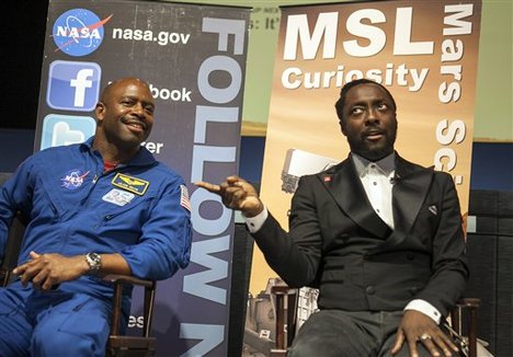 Musician Will.i.am of The Black Eyed Peas, right, and former NASA astronaut Leland Melvin, left, address bloggers at NASA Social media event at the Jet Propulsion Laboratory in Pasadena, Calif., August 12, 2012, hours before the Mars rover Curiosity is due to land on the surface of Mars.