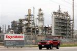 In this April 4, 2005 file photo, a sports utility vehicle drives past an ExxonMobil refinery in Baytown, Texas. Exxon Mobil Corp., the world's biggest oil refiner, will spend more than $1 billion in the next couple of years to increase its global production of cleaner-burning diesel by about 10 percent, the company said Tuesday, Dec. 16, 2008.