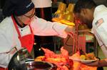 Culinary Specialist 1st Class Susan Graham serves ham to Culinary Specialist 1st Class Carrol Williams during a Christmas dinner held aboard the aircraft carrier USS George H.W. Bush (CVN 77) for the ship's crew and family members.