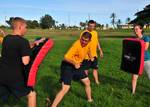 Logistics Specialist 2nd Class Graham Pridham, assigned to the submarine tender USS Frank Cable (AS 40), uses a baton to fight off Engineman 3rd Class Rex Hartung and Machinist's Mate Fireman Sherrell Evans.