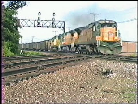 C&NW powered trains cross the BN diamond at Rochelle IL. 5/17/1993