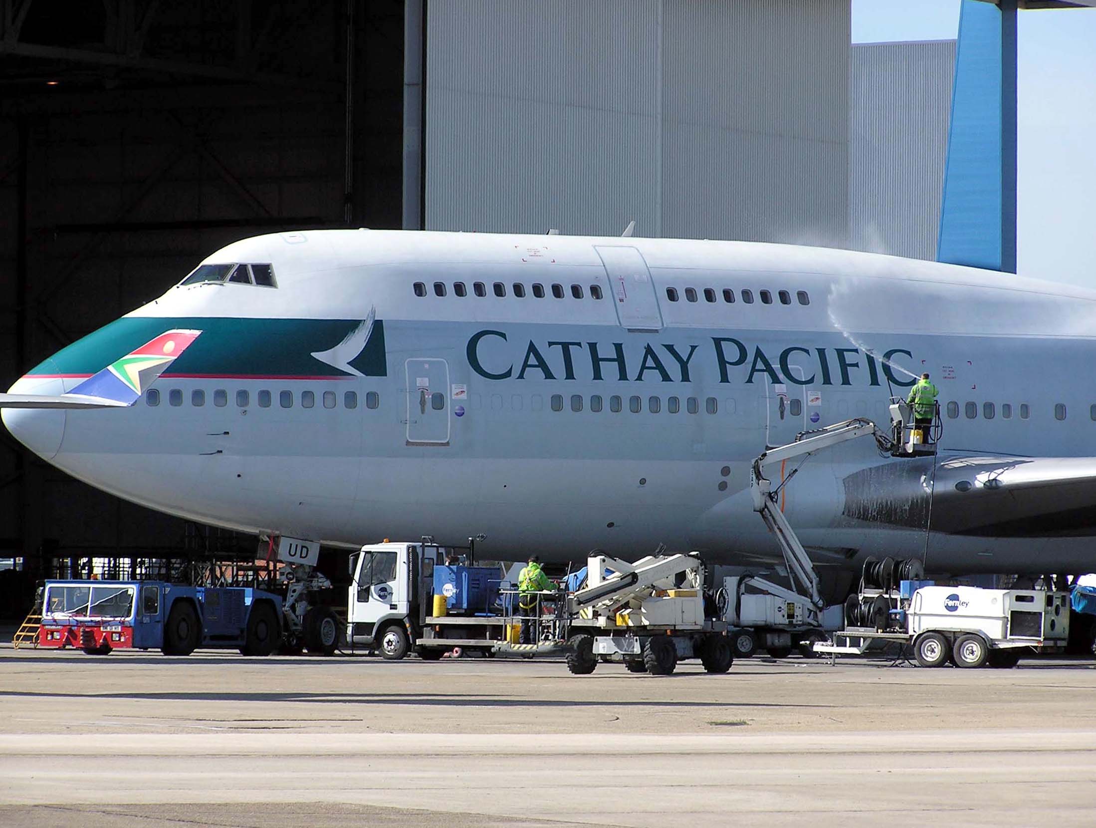 A Cathay Pacific Boeing 747–400 being cleaned at London Heathrow Airport,A South African Airways Wingtip can be seen on the left hand side of the image