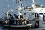 An Italian Coast Guard vessel rescues a boatload of would-be migrants believed to be from North Africa in the waters off the Sicilian island of Lampedusa, Italy, Sunday, Feb. 13, 2011.