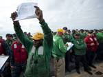 Aviation Boatswain's Mate (Equipment) 1st Class Earl Hendricks holds up the number of his division's life raft as Sailors muster on the flight deck during an abandon ship drill aboard the Nimitz-class aircraft carrier USS Carl Vinson (CVN 70).