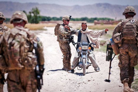 A U.S. Army paratrooper with the 82nd Airborne Division's 1st Brigade Combat Team searches a passerby while sweeping a road for improvised explosive devices June 30, 2012, Ghazni Province, Afghanistan.