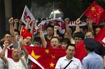 Anti-Japan protesters shout slogans while marching with Chinese national flags and banners towards the Japanese Embassy in Beijing Saturday, Aug. 18, 2012. Japan on Friday expelled several Chinese who were arrested after they landed on disputed islands, but the activists vowed to take new trips there that could again inflame territorial tensions in North Asia.