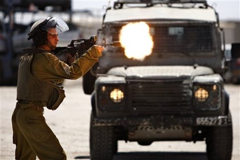 An Israeli Soldier shoots rubber bullets towards Palestinian protesters, not pictured, during a demonstration supporting prisoners in Israeli jails outside the Ofer military prison, near the West Bank city of Ramallah, Tuesday, Aug. 28, 2012.