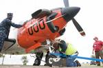 Navy Facilities Engineering Command workers anchor a T-34C Turbomentor training aircraft as a static display at Naval Air Station Corpus Christi.