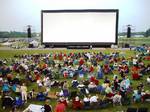 Giant inflatable outdoor movie screen Movies are also commonly shown on airliners in flight, using large screens in each cabin or smaller screens for each group of rows or each individual seat; the airline company sometimes charges a fee for the headphones needed to hear the movie's sound.