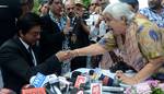 A Fan shake hamds with Indian Bollywood film actor Shah Rukh Khan speak a press conference in Srinagar on September 6, 2012. Shah Rukh, who completed his nine-day shooting schedule in the Valley for Indian filmmaker Yash Chopra's untitled project, is confident that people from South Asia and South East Asia will visit the valley when they watch the movie, which has been extensively shot in Kashmir.