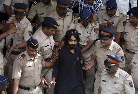 Indian policemen escort political cartoonist Aseem Trivedi, center in black as they leave a court in Mumbai, India, Monday, Sept. 10, 2012.