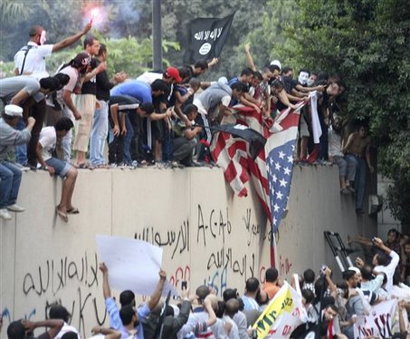 Protesters destroy an American flag pulled down from the U.S. embassy in Cairo, Egypt, Tuesday, Sept. 11, 2012.