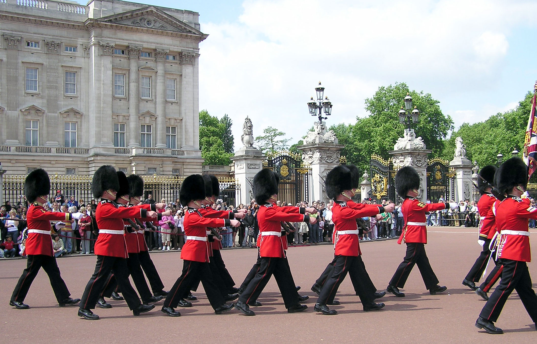 Lines of men wearing large black bearskin hats and red tunics.