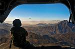 NANGARHAR PROVINCE, Afghanistan — U.S. Army Spc. Devon Boxa from San Angelo, Texas, a member of Company B, 7-158th Aviation Regiment, admires the Afghan landscape out the back door of her CH-47D Chinook helicopter as another Chinook follows. The choppers were flying from Kabul to Jalalabad Dec. 17. (U.S. Army photo by Spc. Ken Scar, 7th MPAD)