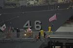 Sailors aboard the guided-missile frigate USS Curts (FFG 38) lower the flag on the fantail of the ship during evening colors.