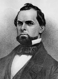 Back and white photo of a bearded man wearing a suit